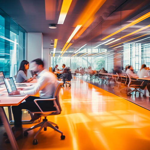 Soft-focus image showing individuals engaged in various tasks within an office environment