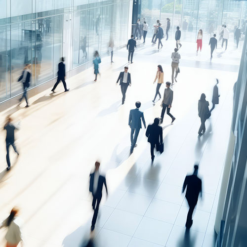 A bustling crowd of people walking through a spacious interior of a large building