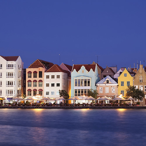 Colorful buildings lining the waterfront in Willemstad Curaçao at dusk