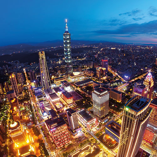 A panoramic view of Taipei at night, with the illuminated Taipei 101 tower dominating the skyline