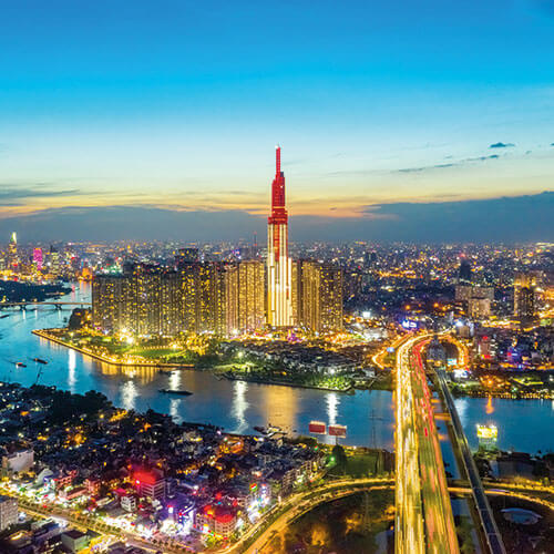 Ho Chi Minh City skyline at night with the Bitexco Financial Tower illuminated and the Saigon River winding through the city