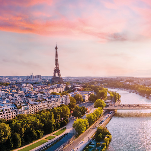 An aerial view of Paris, France, with the Eiffel Tower, Seine River, and cityscape at sunset