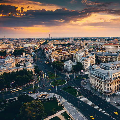 An aerial view of  Bucharest, Romania, at sunset, featuring the Palace of the Parliament and the city's historic center