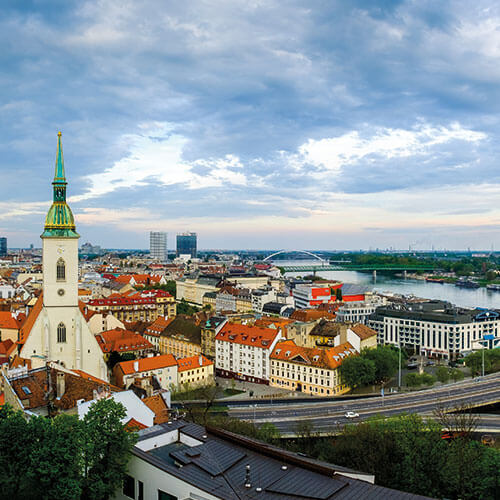 A panoramic view of Bratislava, Slovakia, with St. Martin's Cathedral, the Danube River, and the Slovak National Uprising Bridge