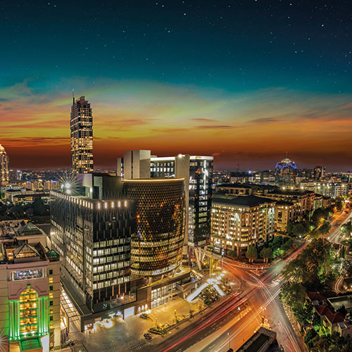 A stunning night shot of Sandton, Johannesburg, South Africa, showcasing the city's modern skyline and illuminated streets