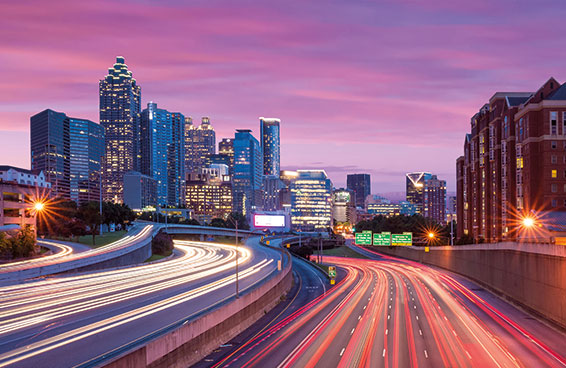 A shot of Atlanta skyline at dusk with a highway filled with traffic