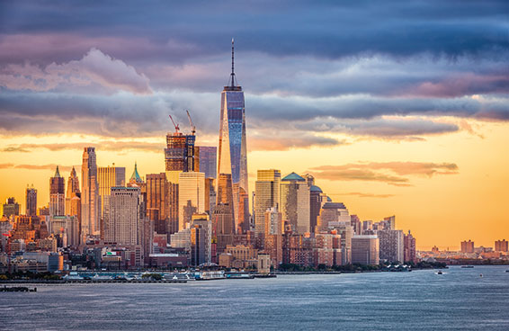 An aerial view of New York City skyline at sunset, with One World Trade Center