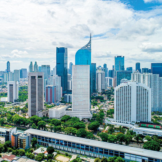 A scenic view of the Jakarta skyline with several tall skyscrapers, including the iconic Gama Tower