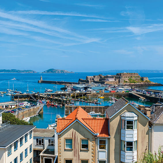 A view of St. Peter Port harbor in Guernsey, with Castle Cornet and the Little Russel Island in the background