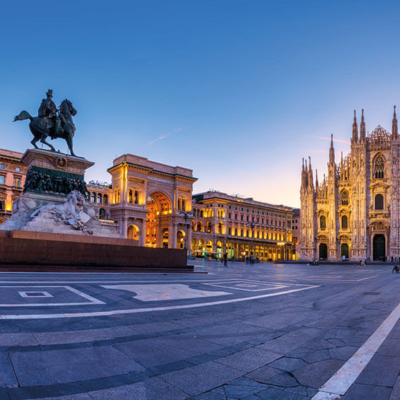 An aerial view of the Piazza del Duomo in Milan at dusk, with the Duomo di Milano and the Vittorio Emanuele II Gallery