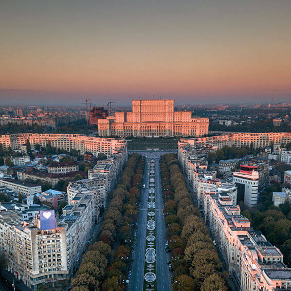 An aerial view of the Palace of Parliament in Bucharest, Romania, at sunset