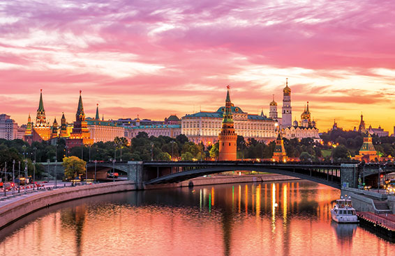 Sunset view of the Kremlin and St. Basil's Cathedral in Moscow with the Moskva River in the foreground