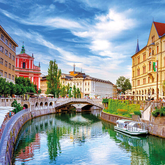 A view of the Ljubljanica River in Ljubljana, with the Triple Bridge and the Franciscan Church of the Annunciation in the background