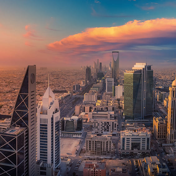 A cityscape of Riyadh, Saudi Arabia, at sunset, with the Kingdom Centre