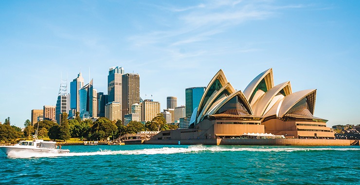 A panoramic view of the Sydney Opera House with the Sydney Harbour Bridge visible in the background