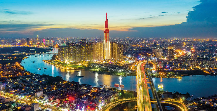 Ho Chi Minh City skyline at night with the Bitexco Financial Tower illuminated and the Saigon River winding through the city