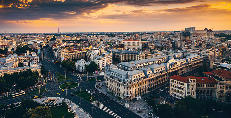 An aerial view of  Bucharest, Romania, at sunset, featuring the Palace of the Parliament and the city's historic center