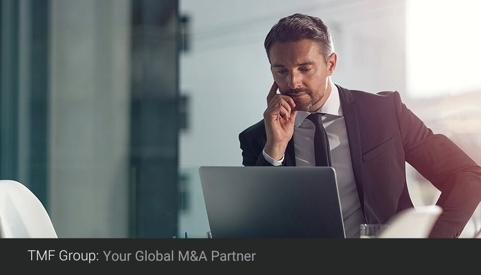 tmf group man sitting with a laptop