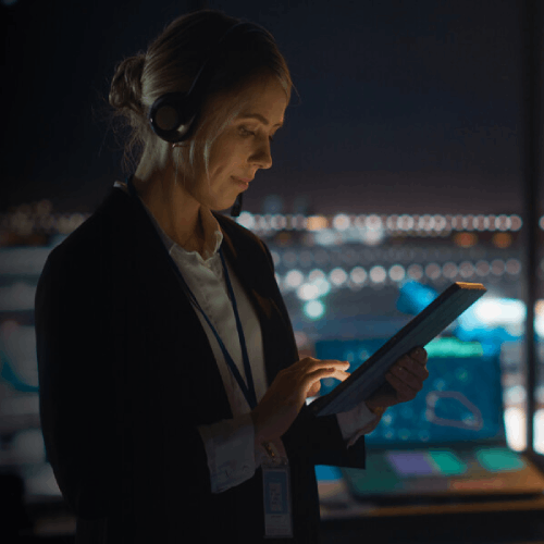 A professional woman in a business suit uses a tablet