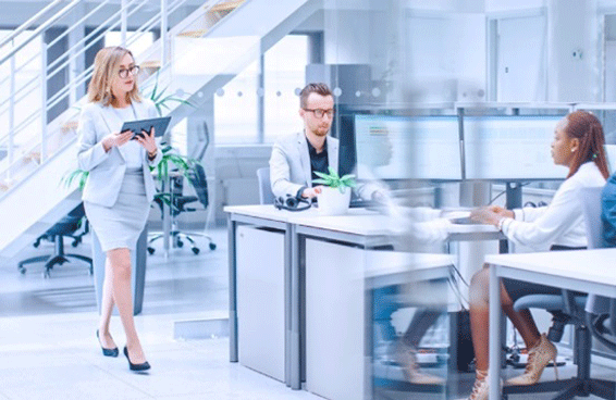 A business-suited woman addresses a group, emphasizing compliance and reporting in a corporate environment